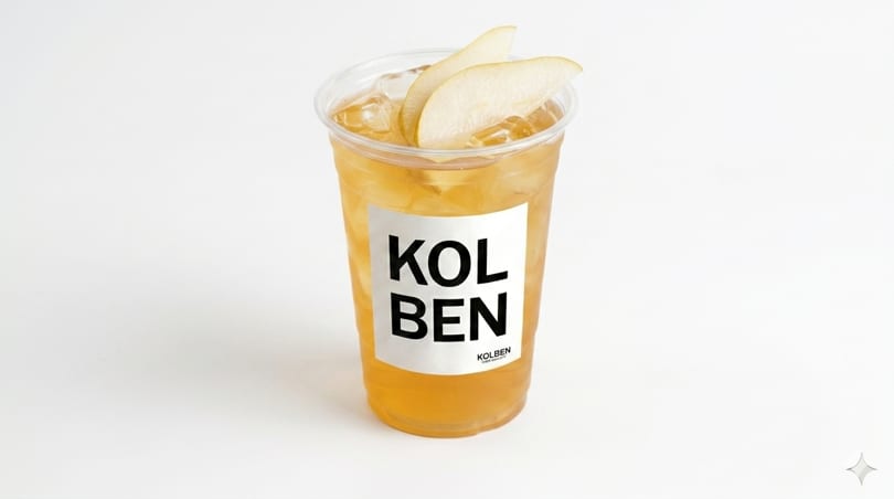 Iced tea with pear slices in a clear plastic cup with a "KOLBEN" label.
